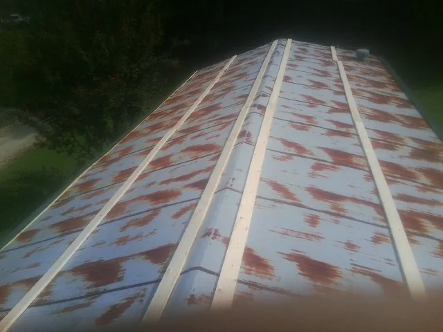 Rusted metal roof panels with new wood purlins before replacement — Storm Damage Roof Repair in Moyock by Roofing Brothers