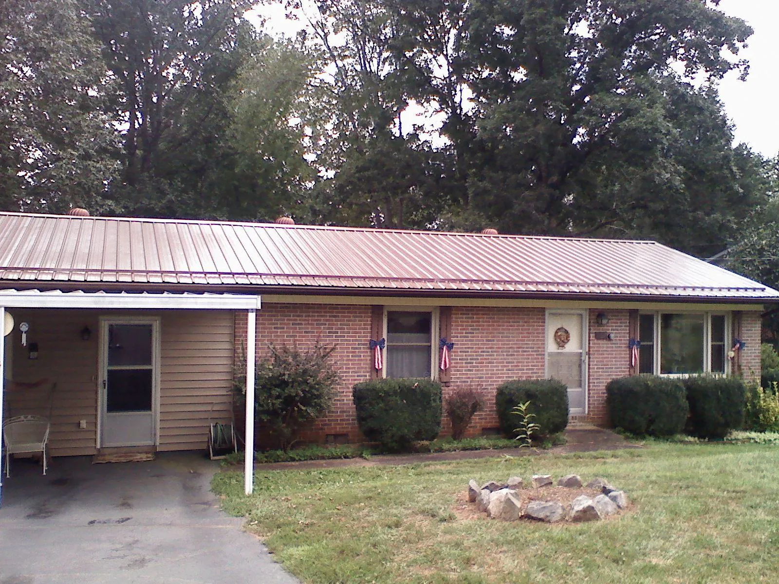 Bronze metal roof and carport on a brick ranch home — Roof Repair work by our crew in Moyock