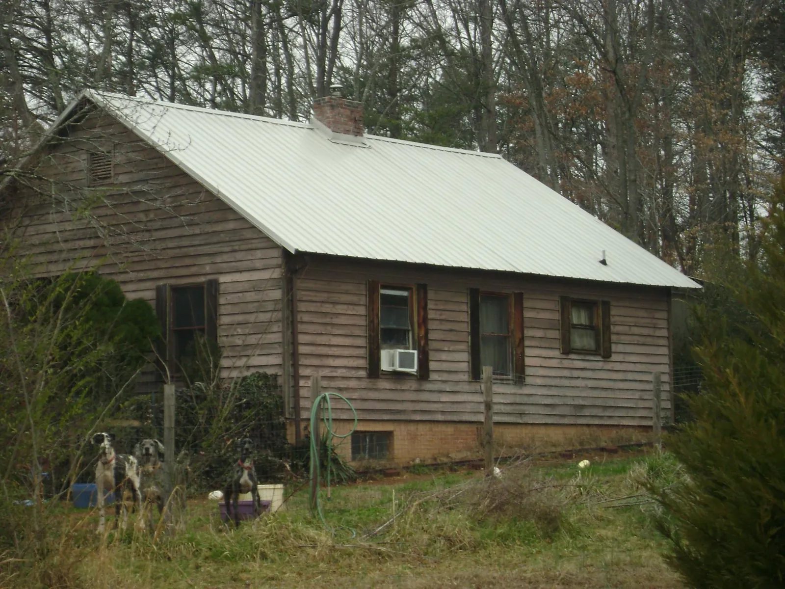 White metal roof on an old wood sided farmhouse, from a Metal Roof Installation job in Moyock